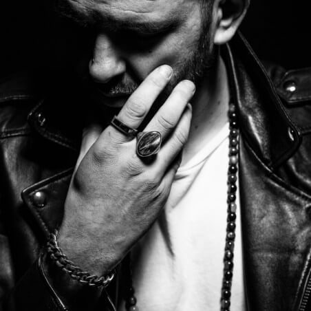 Photo d'une chevalière homme portée par un homme en blouson de cuir.