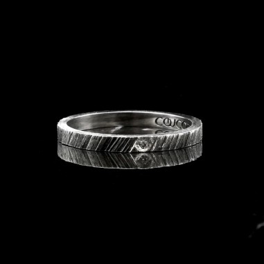 Photo de l'alliance fine diamant blanc modèle tungstène vue de face sur fond marbre noir.