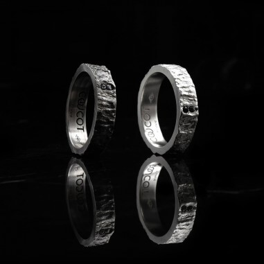 Photo sur un fond marbre noir des deux alliances homme avec diamant modèle Hyperion.