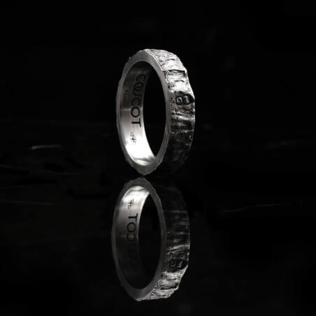 Photo de la bague alliance homme avec diamant blanc vue de côté sur fond marbre noir.