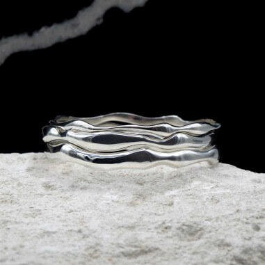 Photo mood sur une pierre blanche des joncs en argent modèle Halo.