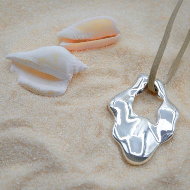 Photo mood dans le sable du collier sautoir modèle Halo.