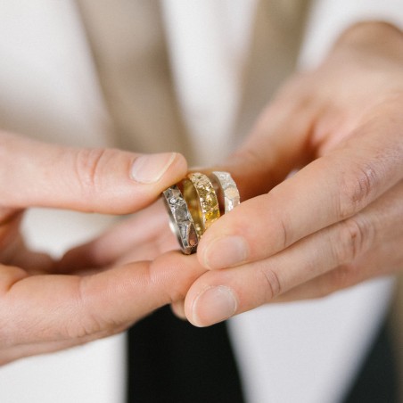 Photo d’une main d’homme qui porte différentes couleurs d'alliance homme avec diamant modèle A76.